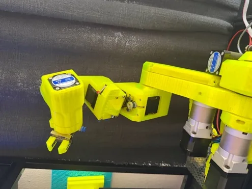 VOLT, the yellow six-axis arm, reaching forward with its gripper open
