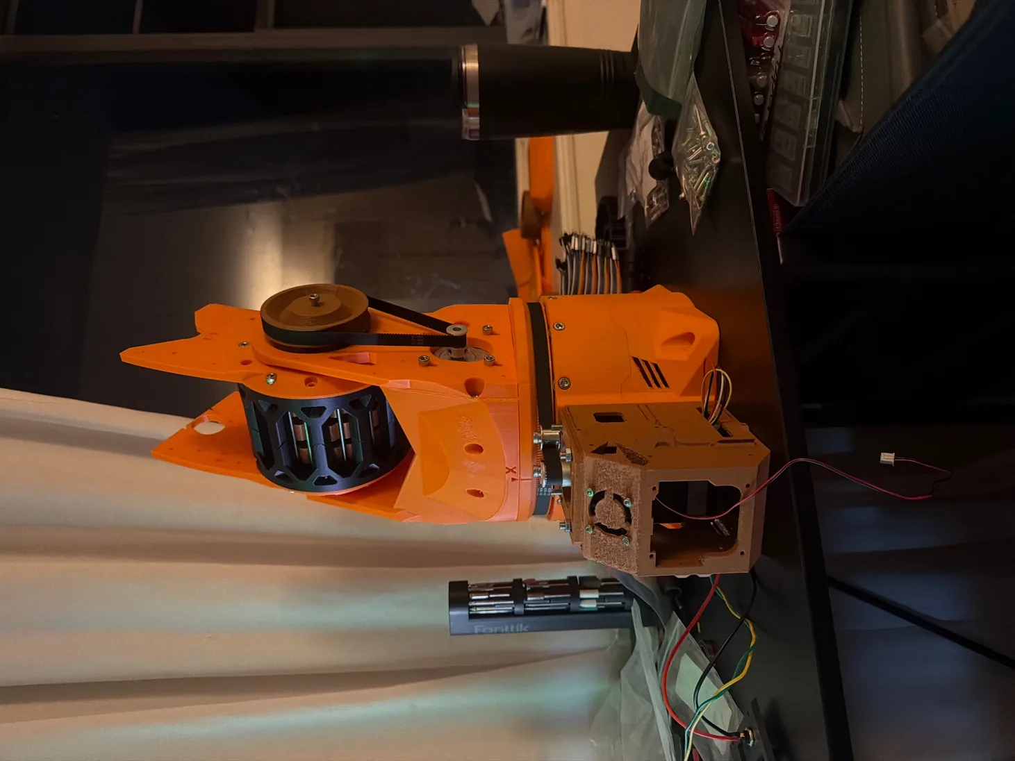 Close-up of an orange printed joint with its motor and belt drive