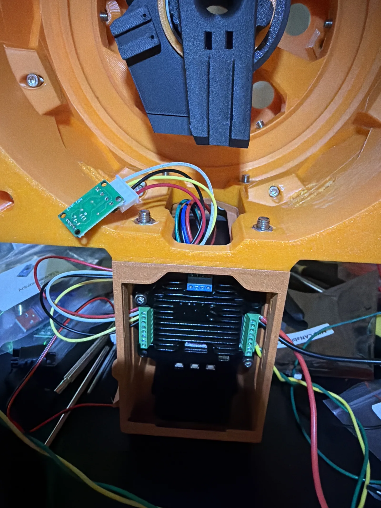The arm base with control boards and colored wiring mounted inside