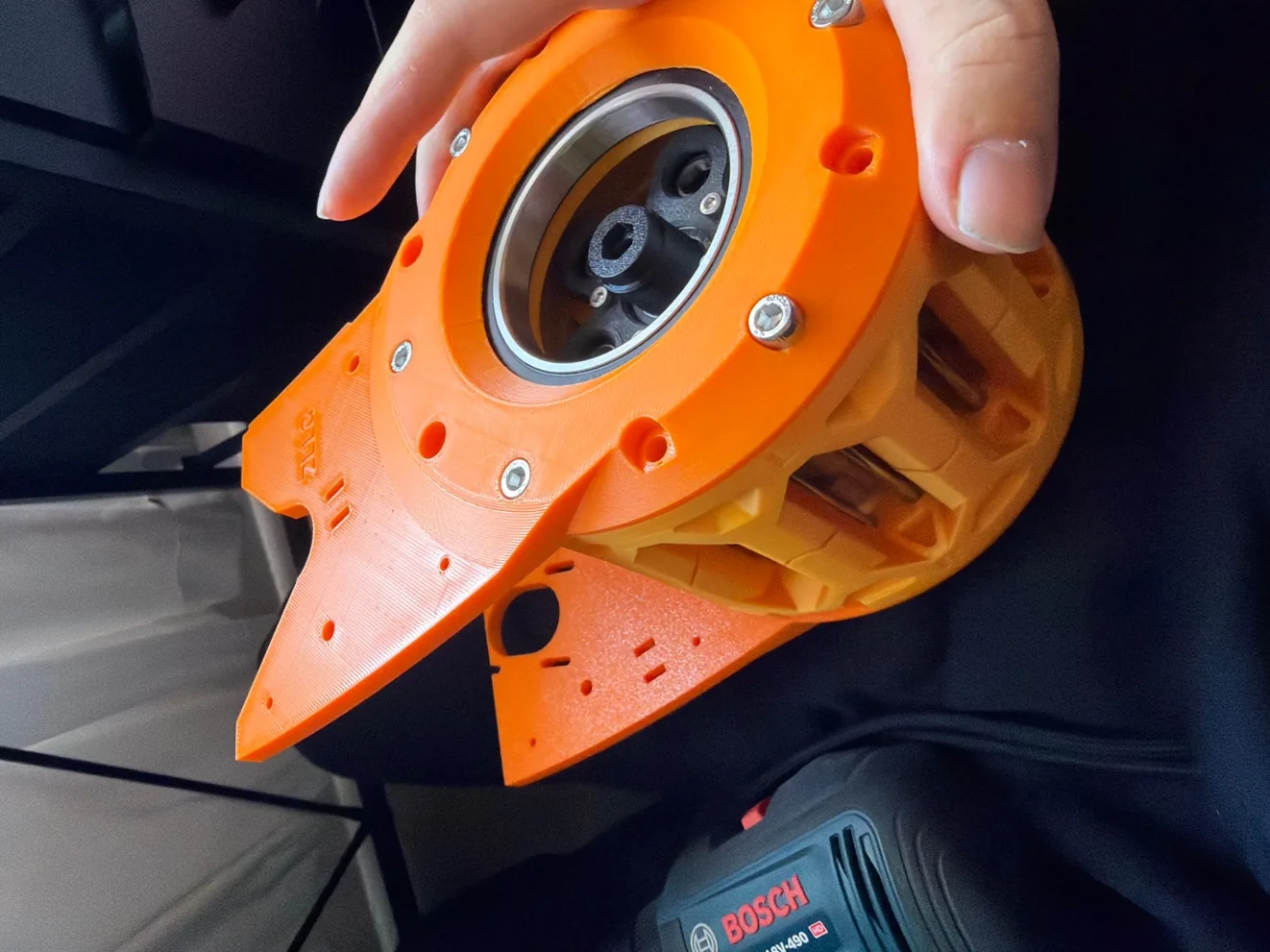 A hand holding the printed cycloidal gearbox housing