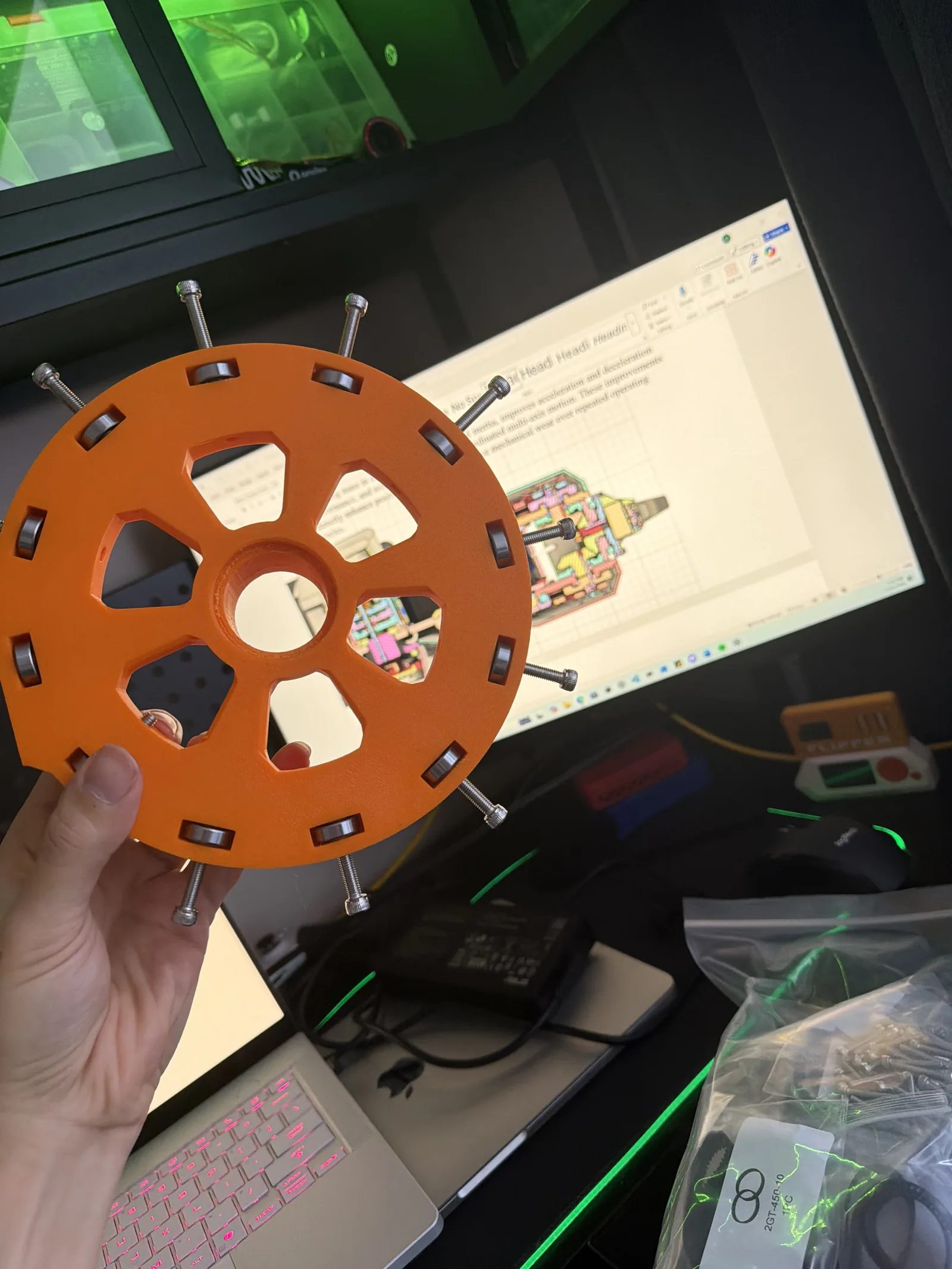 A hand holding the flat cycloidal output plate with its pins fitted