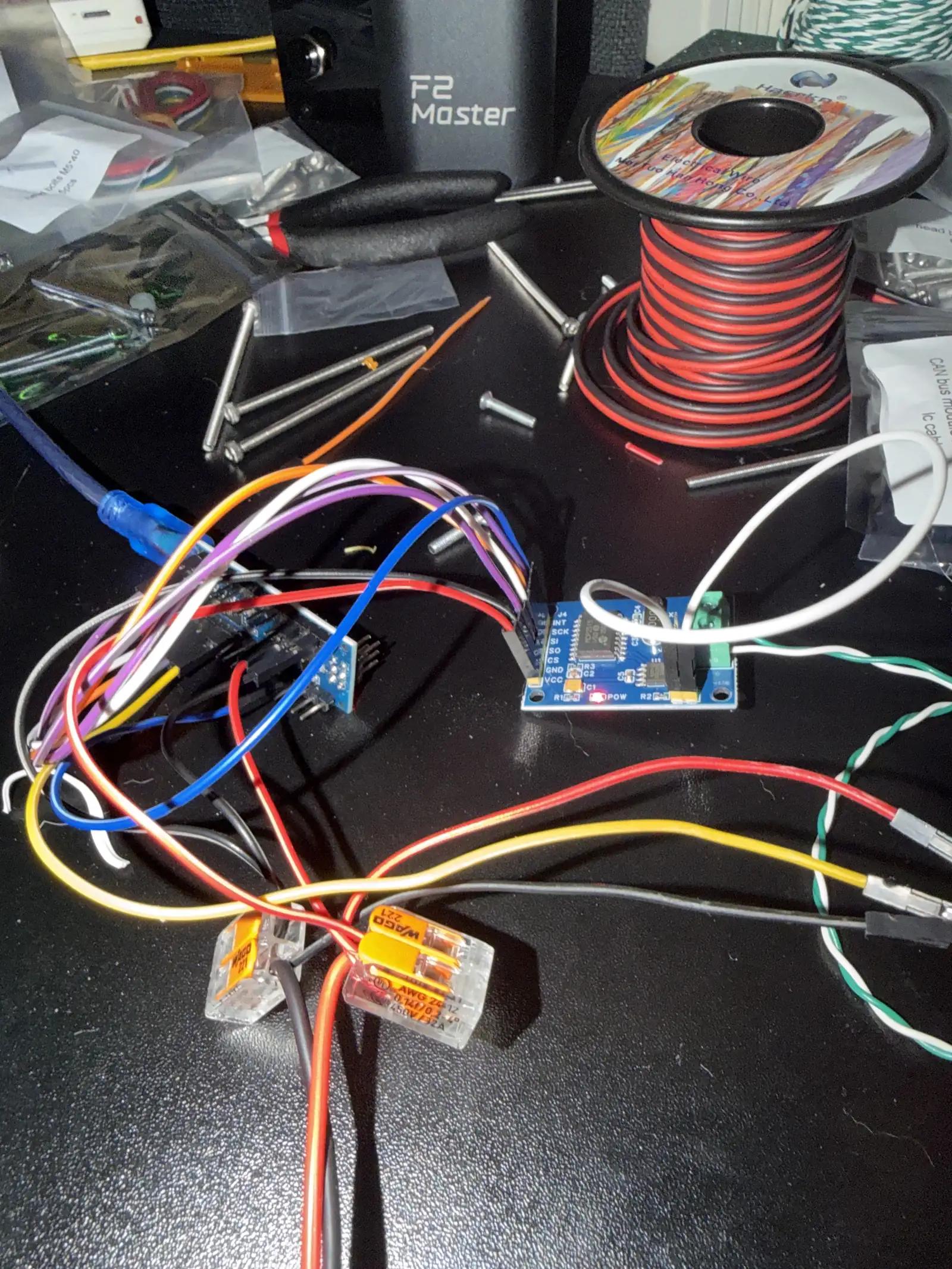 A driver board wired into a loom of colored conductors beside a spool of power cable