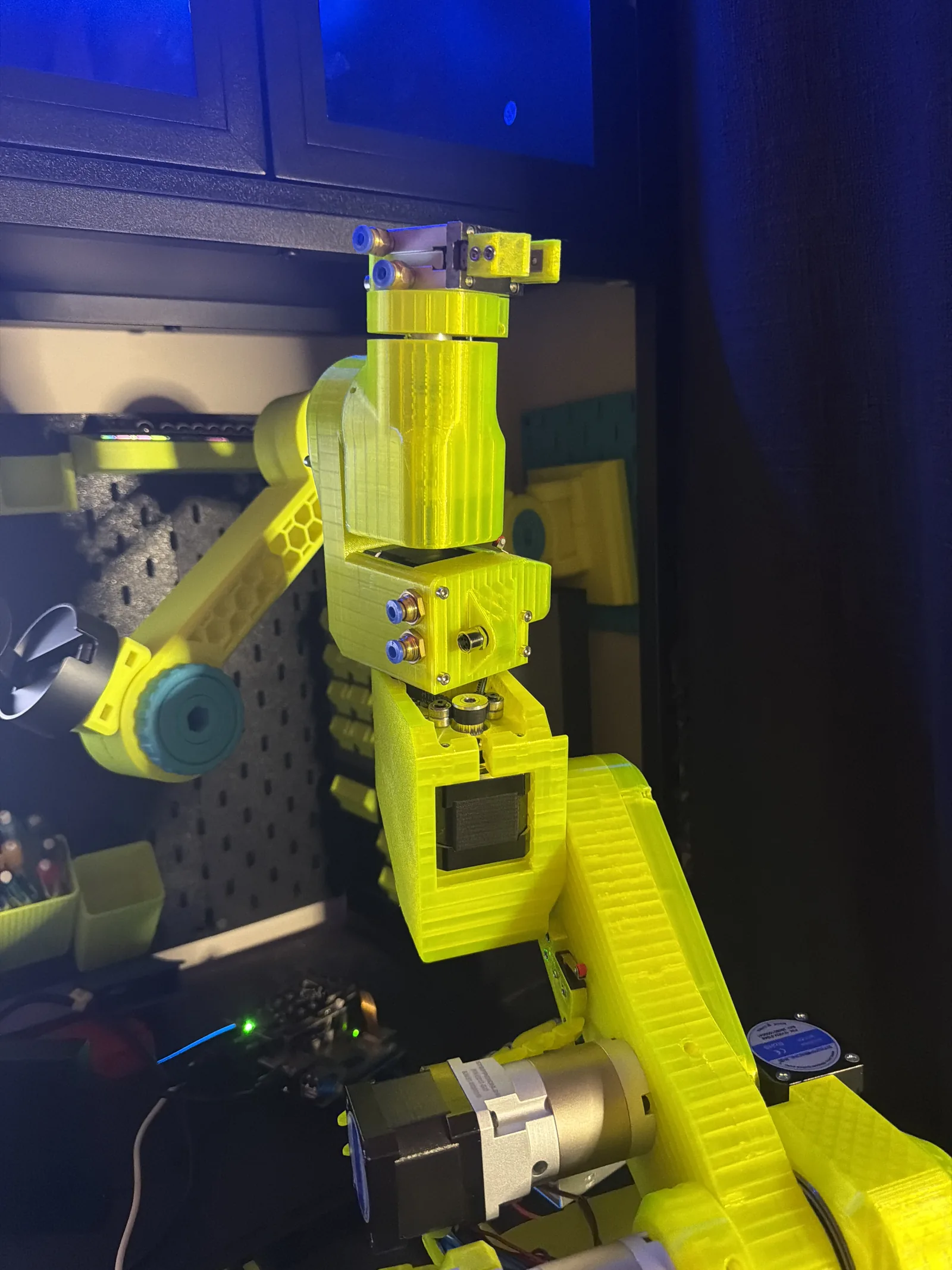 VOLT with a camera mounted above its wrist, lit blue against a pegboard