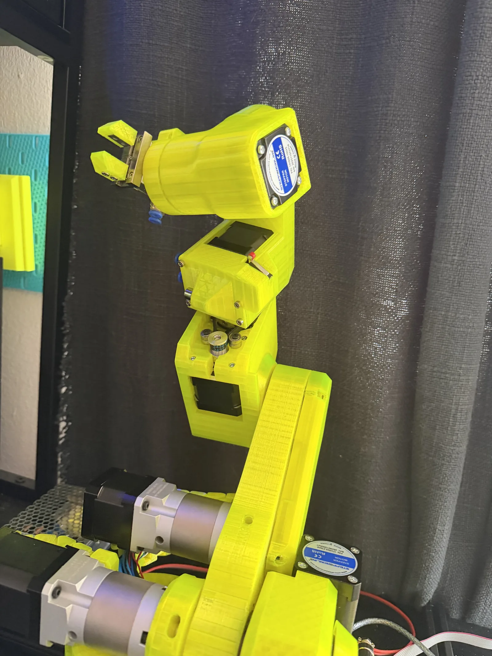 VOLT standing fully assembled in yellow, its six joints and stepper motors visible