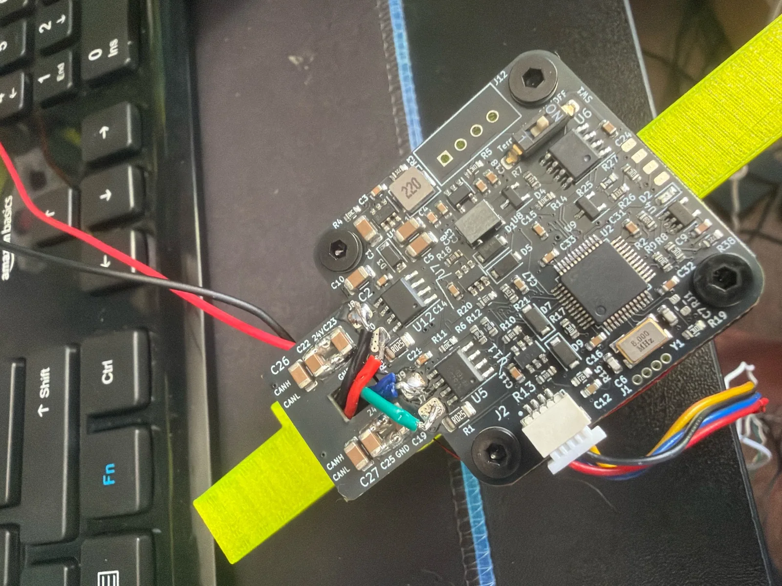 The gripper's driver PCB wired up on a yellow printed bracket
