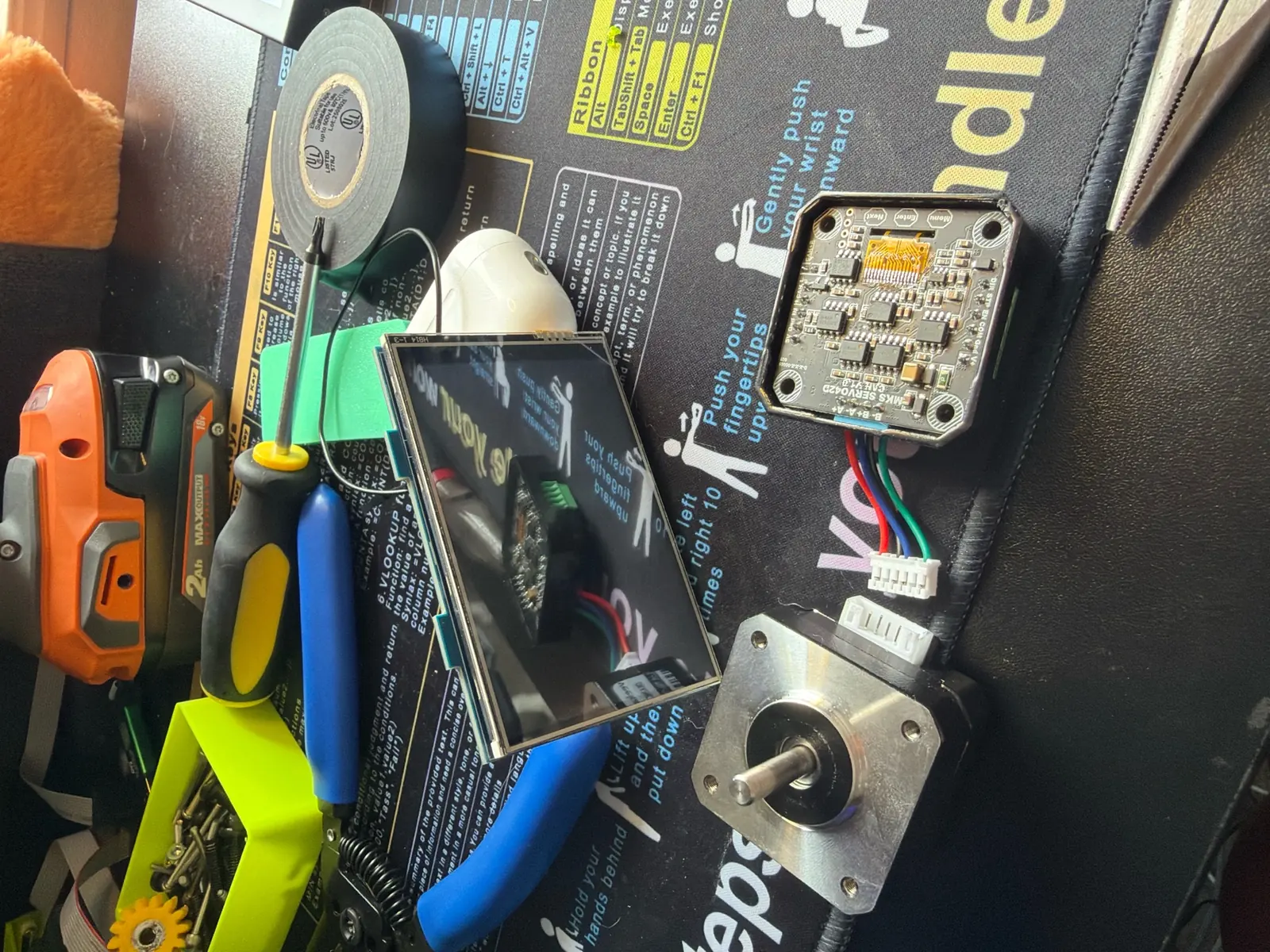 The gripper's stepper motor and driver board laid out on the bench