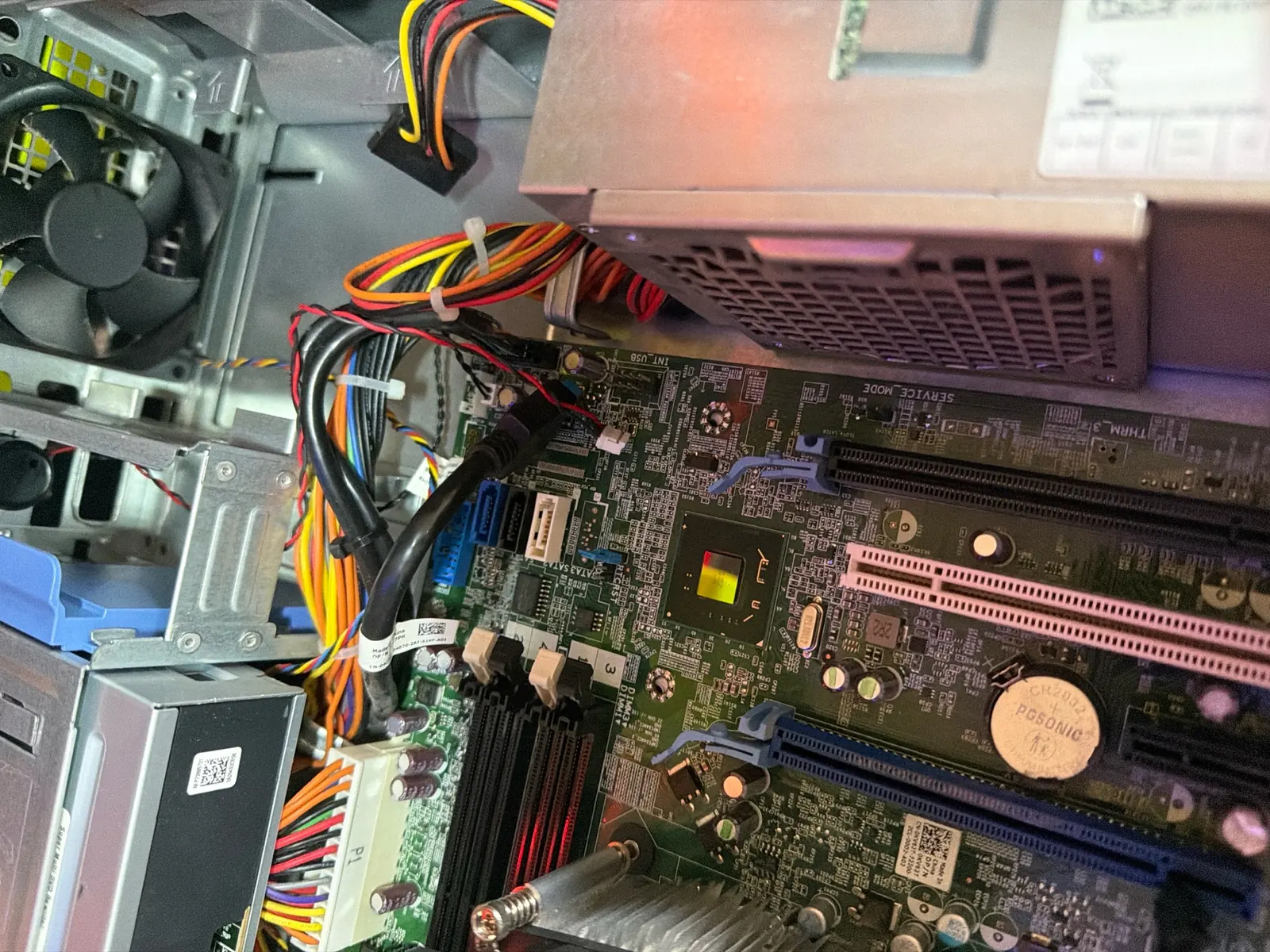 A desktop machine opened up with its motherboard and power cabling exposed