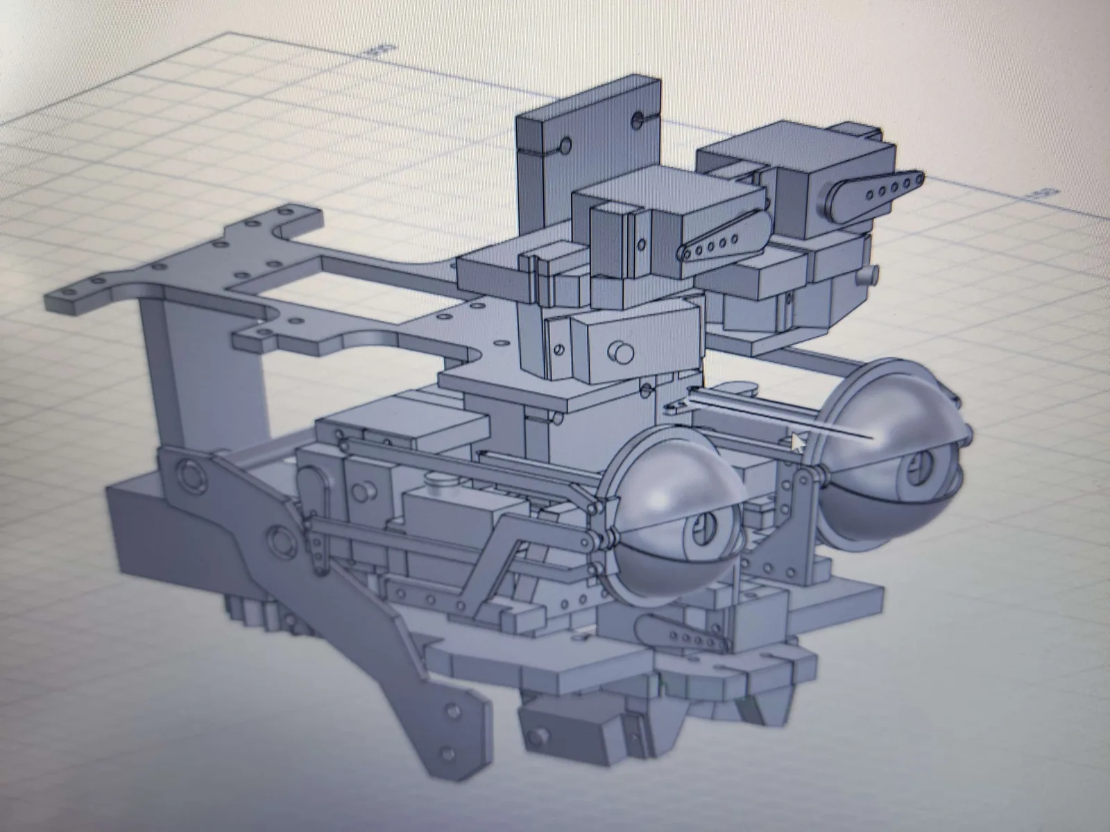 CAD assembly of a humanoid head showing the articulated eye mechanism and its linkages
